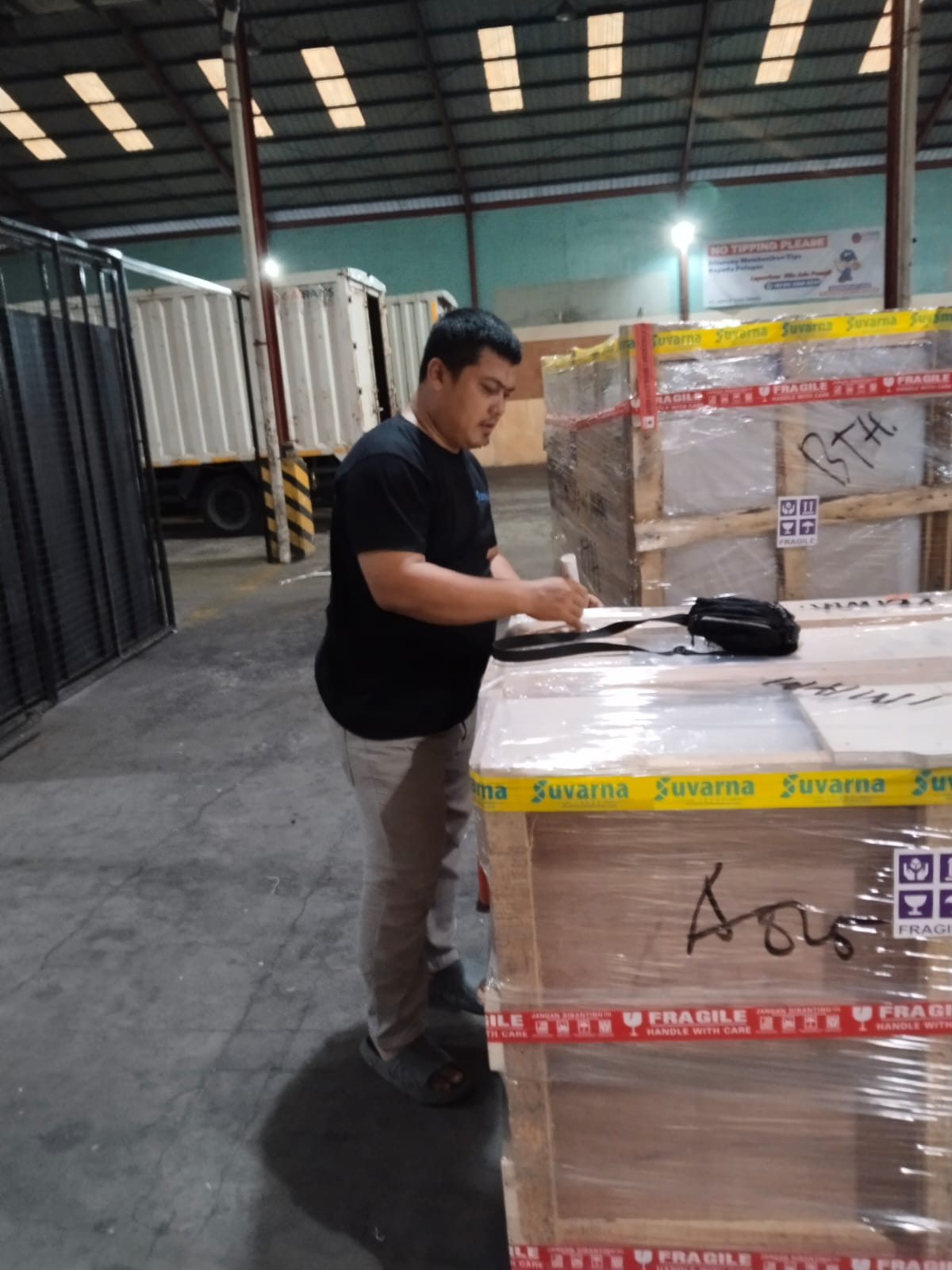 Staf Suvarna memeriksa dokumen dan kargo di gudang